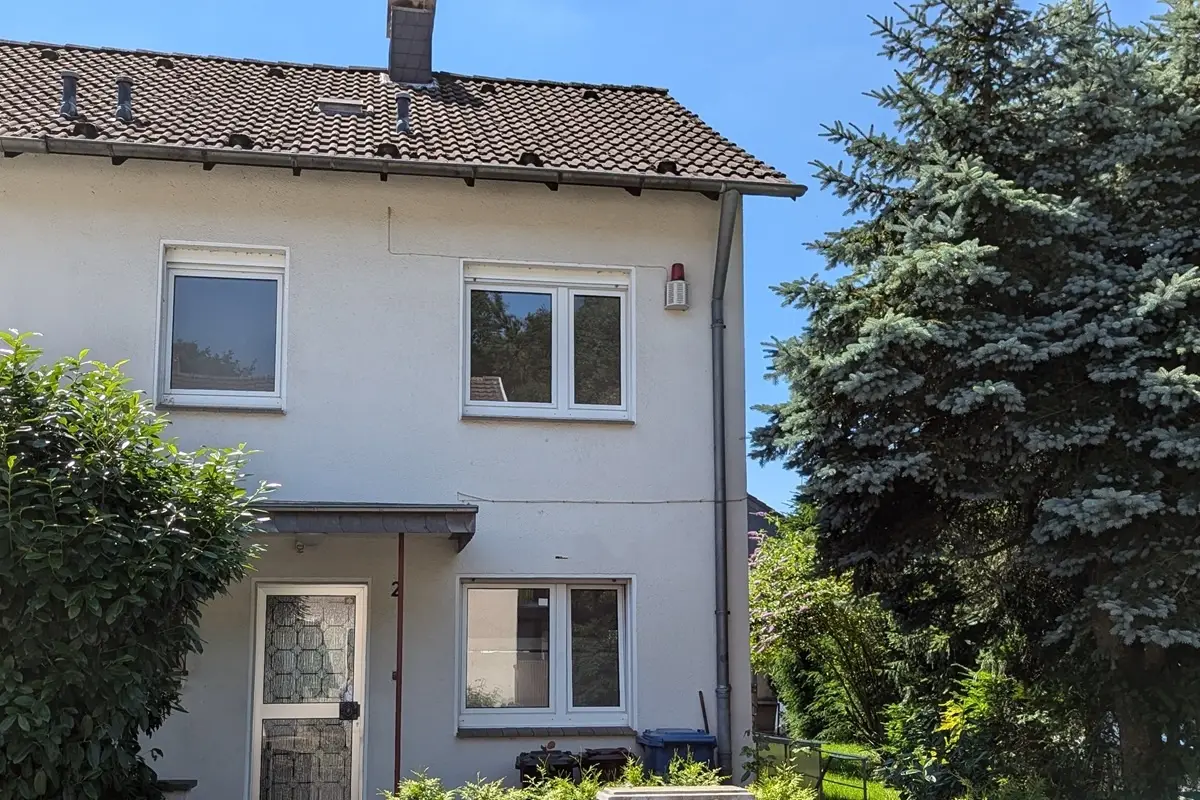 Einfamilienhaus mit Satteldach und Vorgarten.