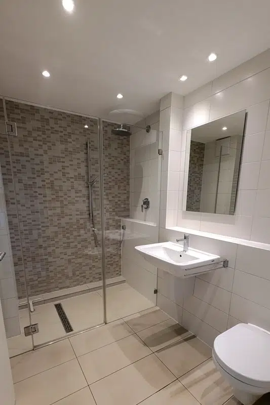 Modernes Bad mit ebenerdiger Dusche und Fliesen