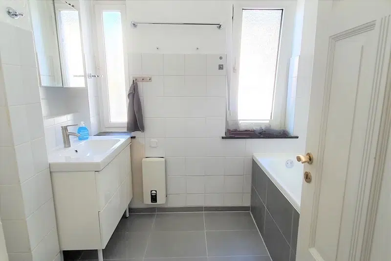 Helles Badezimmer mit Badewanne und Fenster