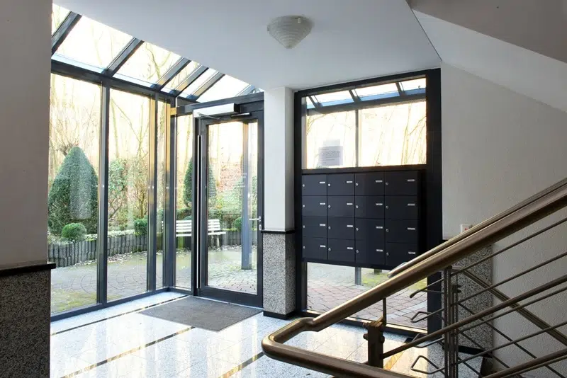 Hauseingang mit Glasdach und Garten