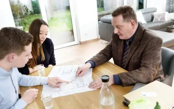 Immobilienprofi berät Paar am Tisch